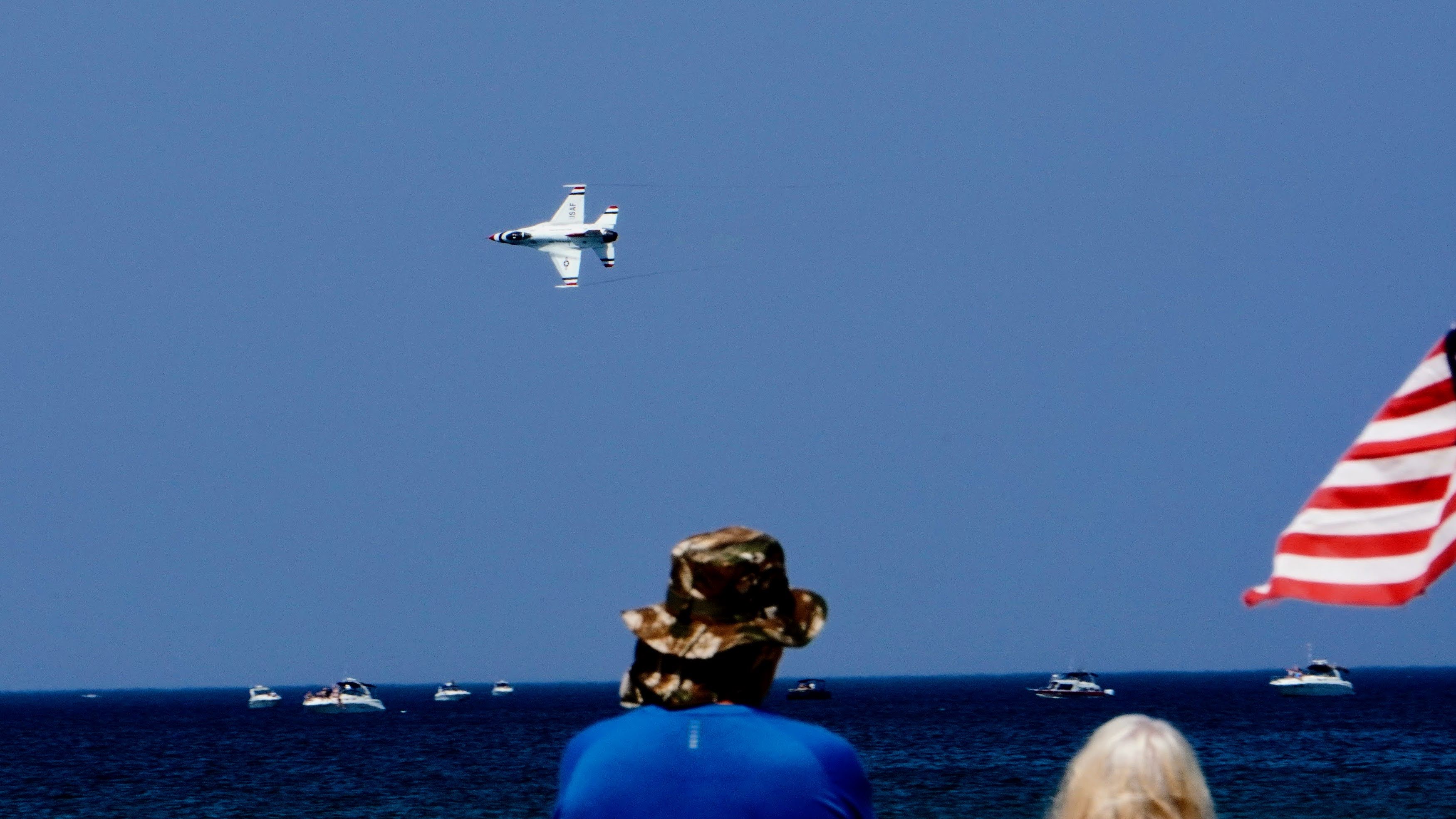 A Thunderbird passes by the spectators as a man watches from Marquette Beach.